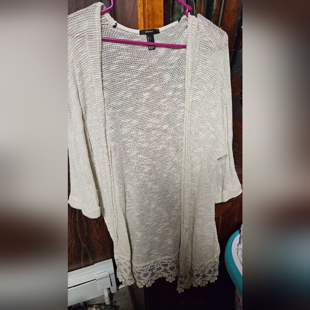Flowy oversized cardigan with detailed design on hem.